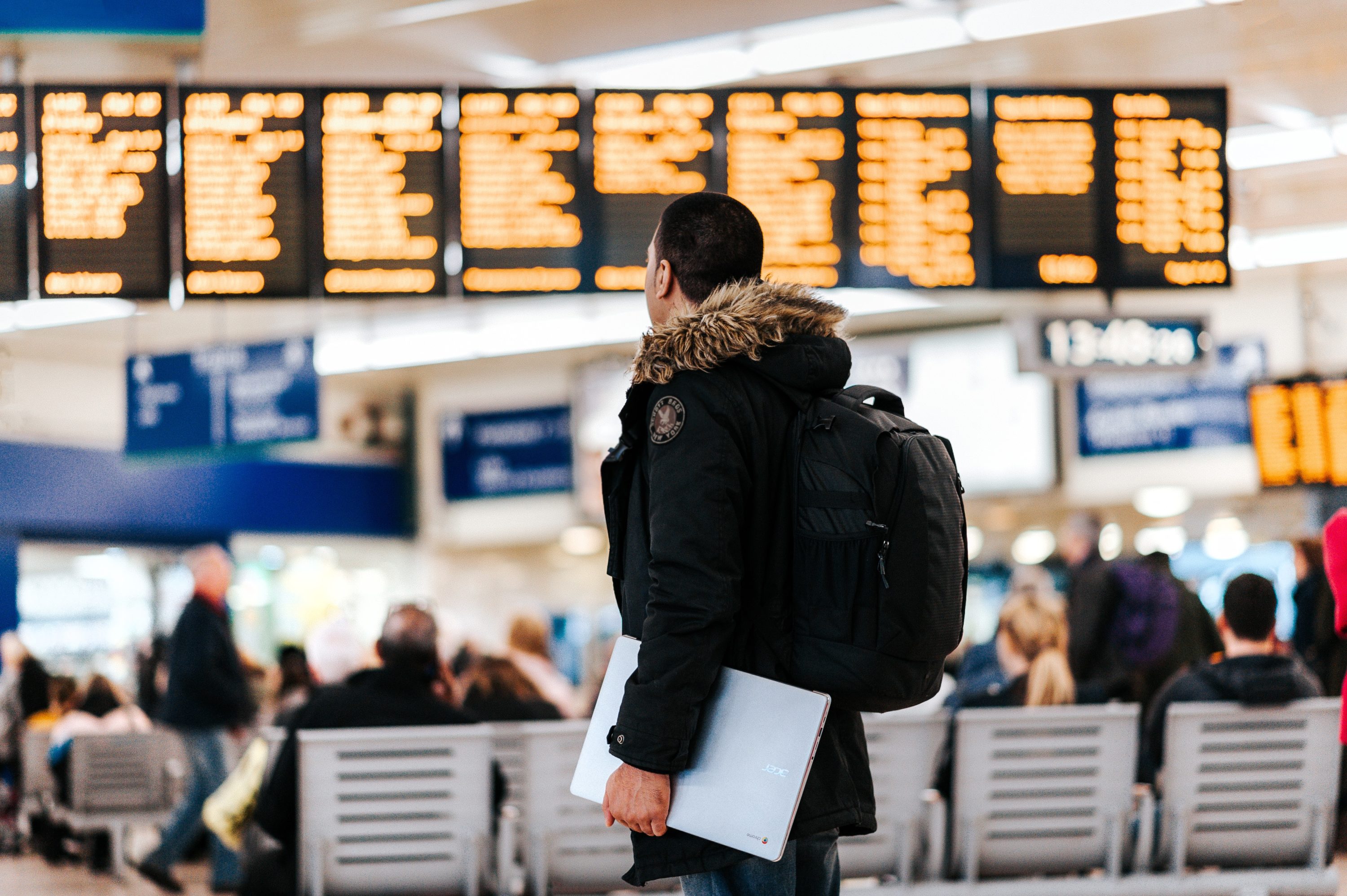 Man walking in airport looking at flight board